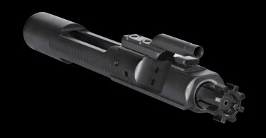 Close-up of an AR-15 bolt carrier group showing the carrier body, gas key, and bolt face against a black background