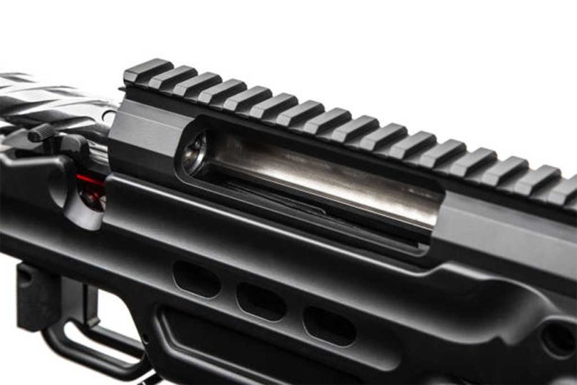 Close-up of an AR-15 upper receiver showing the ejection port and top rail
