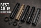 Several AR-15 buffer tubes and related components arranged on a dark workbench surface