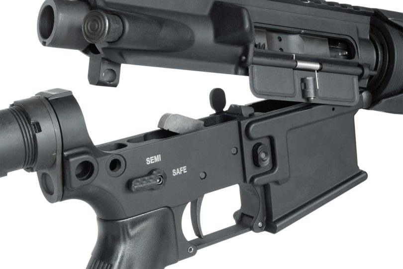 Close-up of an AR-15 upper and lower receiver separated at the takedown pins