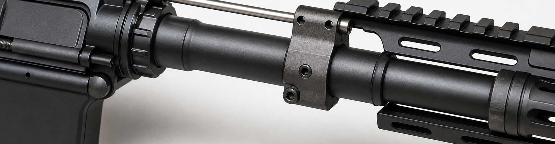Close-up of an AR-15 barrel with gas block and gas tube on a light background
