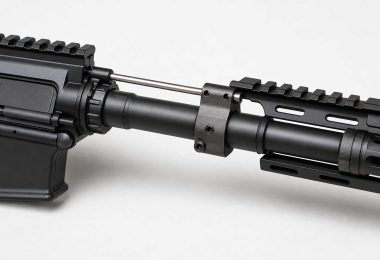 Close-up of an AR-15 barrel with gas block and gas tube on a light background