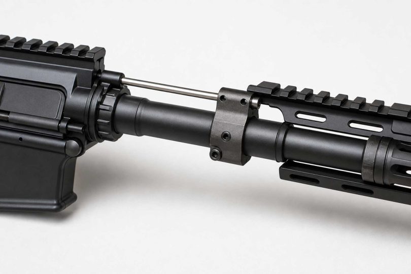 Close-up of an AR-15 barrel with gas block and gas tube on a light background
